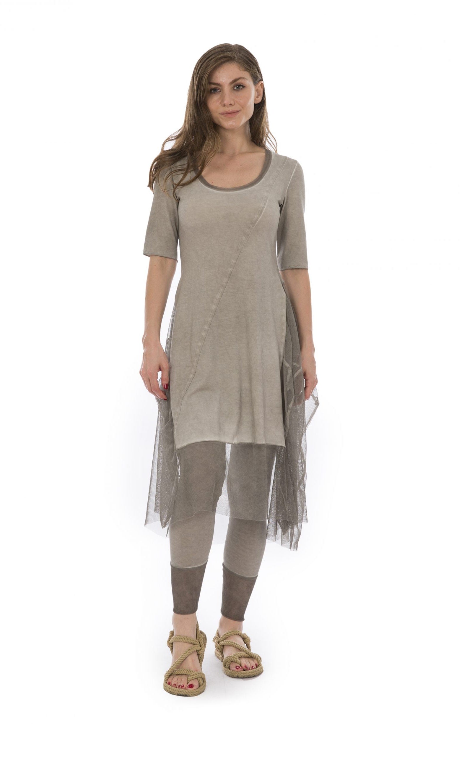 Front full body view of a woman wearing the luukaa stone leggings in the color beige. They have mesh trim on the bottom. On the top the model is wearing the luukaa tunic in beige.