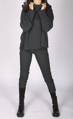 Load image into Gallery viewer, Front full body view of a woman wearing a grey sweater and the luukaa striped lycra pant. This slim pant has a cropped cut and grey and black vertical striping.
