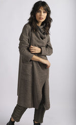 Load image into Gallery viewer, Front full body view of a woman wearing brown cropped pants and the luukaa wrap coat/jacket. This jacket/coat is mink/dark brown with a shawl collar, two front pockets, and long sleeves.
