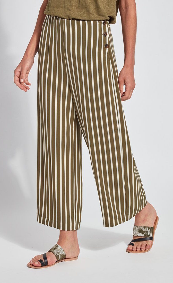 Front bottom half view of a woman wearing the lysse clara pant. This pant has khaki and white stripes. It's wide legged with a flat front and 3 side buttons.