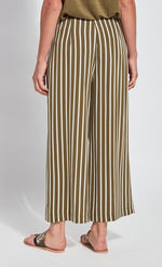 Load image into Gallery viewer, Back bottom half view of a woman wearing the lysse clara pant. This pant has khaki and white stripes. It&#39;s wide legged.
