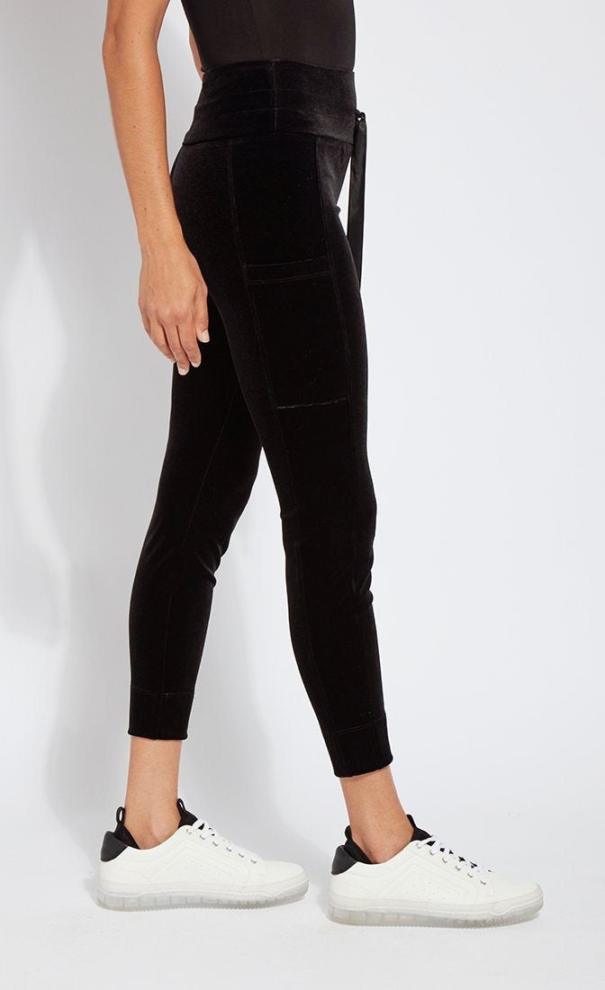 Right side bottom half view of a woman wearing the lysse nook velvet jogger. This black jogger is body hugging like a legging with side pockets and a high-waisted tie waistband.