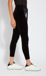 Load image into Gallery viewer, Right side bottom half view of a woman wearing the lysse nook velvet jogger. This black jogger is body hugging like a legging with side pockets and a high-waisted tie waistband.
