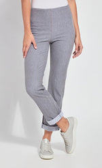 Load image into Gallery viewer, Front bottom half view of a woman standing with one leg crossed in front of the other wearing the Lysse Boyfriend Denim pants. These pants are grey, cuffed, and have a straight leg.
