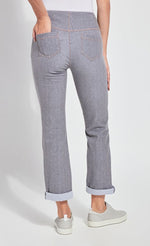 Load image into Gallery viewer, Back bottom half view of a woman standing and wearing the Lysse Boyfriend Denim pants. The woman has her left hand in the back pocket of the pants. The pants are grey, cuffed, and have a straight leg.
