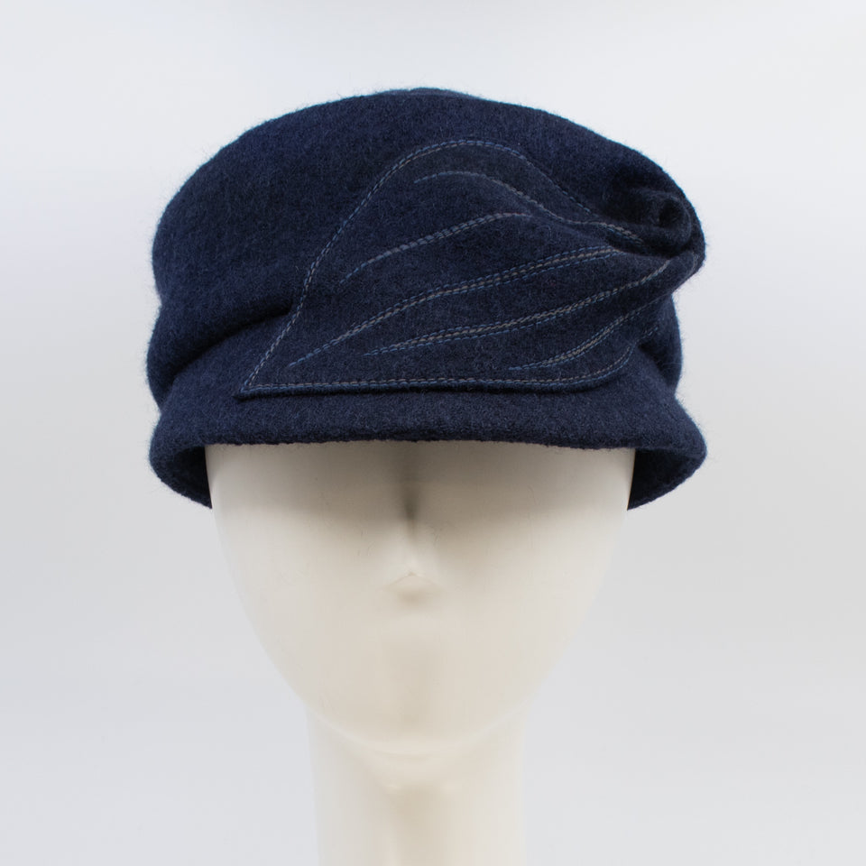 Front view of the mao now hat in navy. This hat has a large stitched leaf on the left side.