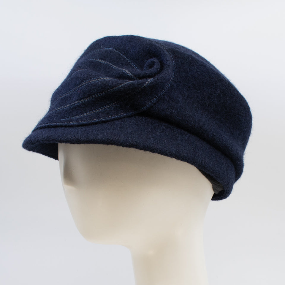 Left side view of the mao now hat in navy. This hat has a large stitched leaf on the left side.