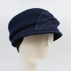 Front right side view of the mao now hat in navy. This hat has a large stitched leaf on the left side and an inner ear warmer