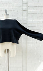 Load image into Gallery viewer, Front top half view of the mxmatthildur black alpaca sweater. This crop sweater has a boatneck, long sleeves, and ribbed trim on the hem, neck, and sleeves.
