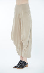Load image into Gallery viewer, Front left sided bottom half view of a woman wearing the matthildur sirocco pant. This pant has a wide leg, two front pockets, a cut that sits above the ankles, and extra fabric infront of the knees.
