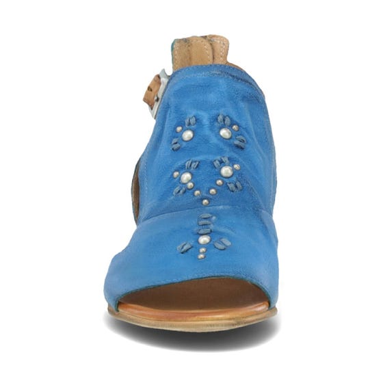 Front view of the miz mooz canary sandal in the color denim. This sandal has an open toe, a mid-heel, a buckle strap around the ankle, and exposed sides.