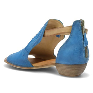 Back, inner side view of the miz mooz canary sandal in the color denim. This sandal has an open toe, a mid-heel, a buckle strap around the ankle, and exposed sides.
