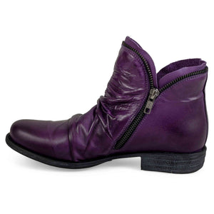 Inner view of the miz mooz luna bootie in a deep dark purple color. This flat bootie has a zipper on the side and decorative zipper trim around the front and back opening for the foot.