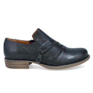 Outer view of the miz mooz lyric oxford shoe. This flat shoe is a slip on. It is black with a decorative zipper over the instep.