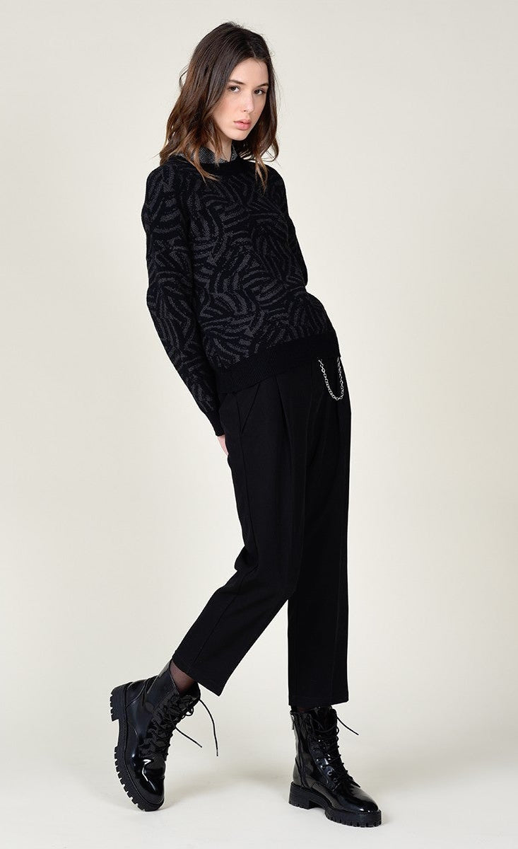 Front full body view of a woman wearing black pants and the molly bracken dark grey zebra sweater. This sweater is grey with black zebra print. It has long sleeves with black cuffs and a relaxed fit.