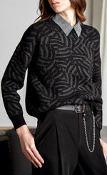 Load image into Gallery viewer, Front top half view of a woman wearing black pants and the molly bracken dark grey zebra sweater. This sweater is grey with black zebra print. It has long sleeves with black cuffs and a relaxed fit.
