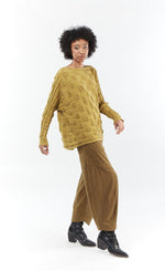 Load image into Gallery viewer, Front full body view of a woman wearing the mxmatthildur bubble sweater and the matching mustard and black striped pants. This sweater features a bubble/jacquard textured fabric print, long sleeves, a boxy shape, and a boat neck.
