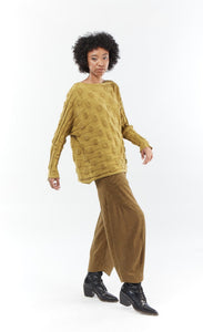 Front full body view of a woman wearing the mxmatthildur bubble sweater and the matching mustard and black striped pants. This sweater features a bubble/jacquard textured fabric print, long sleeves, a boxy shape, and a boat neck.
