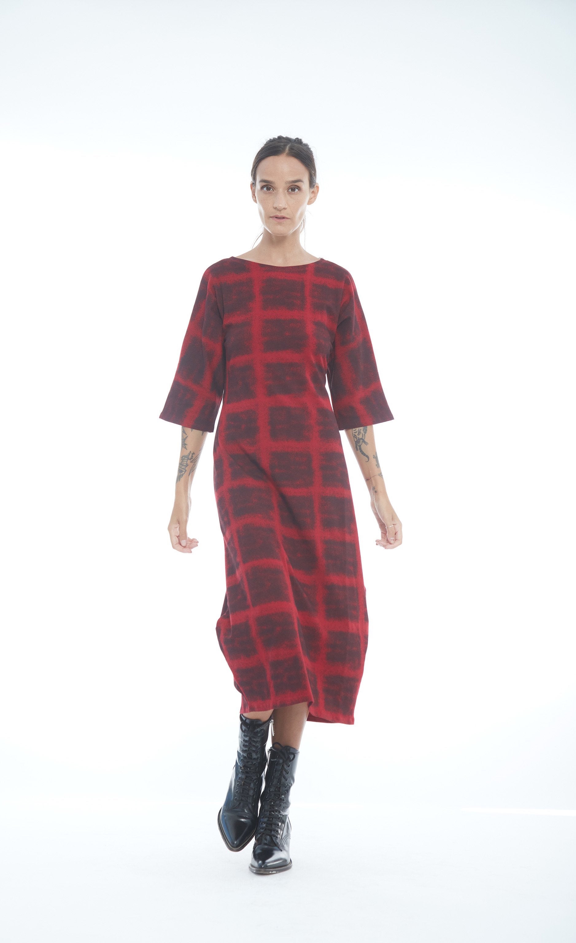 Front full body view of a woman wearing the mxmatthildur mavis dress in a red and black plaid print. This dress has 3/4 length sleeves, large pockets, and sits below the knees.