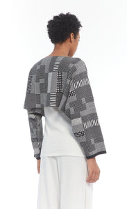 Back top half view of a woman wearing the mxmatthildur vonji sweater. This sweater is white and black plaid patchwork. The sweater has long sleeves and is being worn as a cropped top with a white tank.