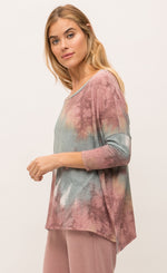 Load image into Gallery viewer, Right side, top half view of a woman wearing the mystree vintage tie dye top and the mystree lounge pant. The top is pink and blue tie dye and has long drop shoulder sleeves and a boxy fit. The bottoms are burgundy pink with a relaxed fit, pockets, and a white waistband.
