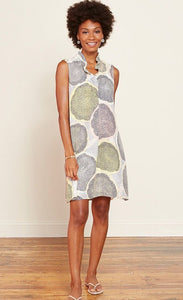 Front full body view of a woman wearing the nic + zoe citrus dress. This v-neck dress is sleeveless and sits above the knees. It is pale yellow and grey with a large citrus slices print in yellow, blow and pink. 