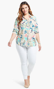 Front full body view of a woman wearing the nic+zoe color splash shirt. This shirt has a button up front, shirt collar, and long sleeves pushed up. It is multicolored with blue, pink, green, and salmon dots and strokes.