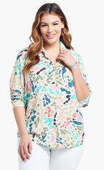 Load image into Gallery viewer, Front top half view of a woman wearing the nic+zoe color splash shirt. This shirt has a button up front, shirt collar, and long sleeves pushed up. It is multicolored with blue, pink, green, and salmon dots and strokes.
