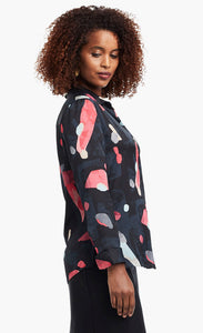 Side view of a woman wearing a black, blue & pink abstract printed kaleidoscope blouse from Nic + Zoe 
