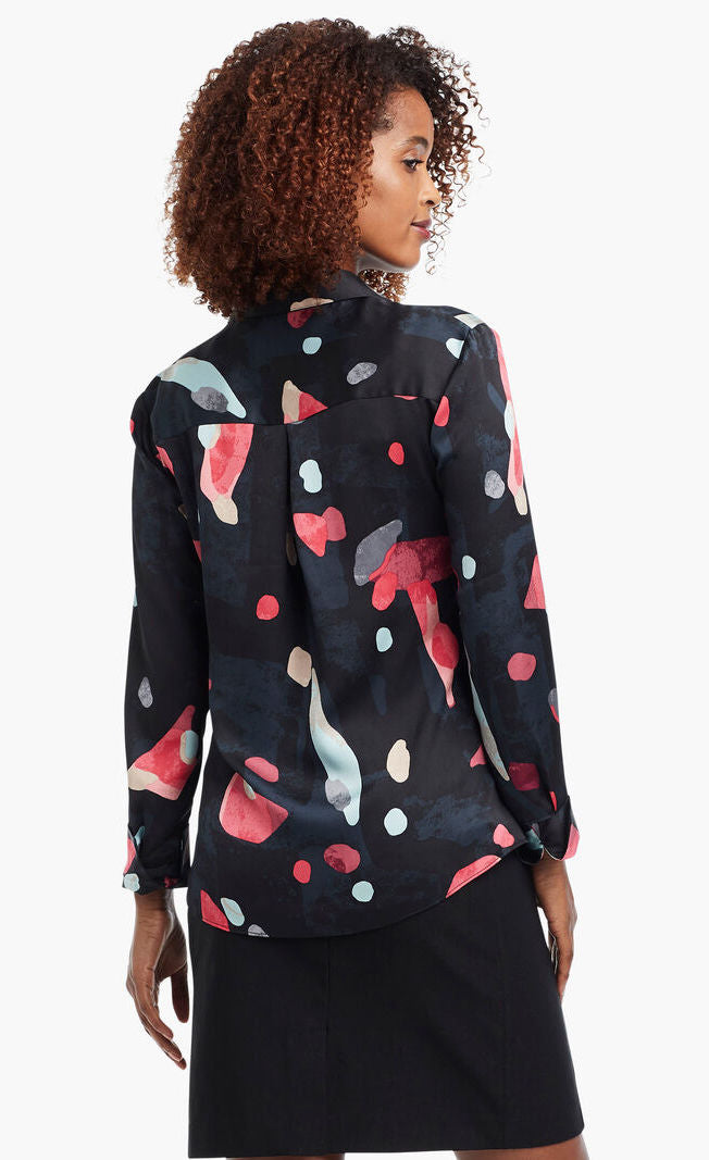 Back view of a woman wearing a black, blue & pink abstract printed kaleidoscope blouse from Nic + Zoe 