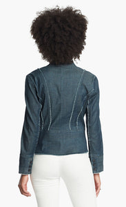 Back, top half view of a woman wearing white pants and the Nic + Zoe Favorite Denim Jacket. The dark denim jacket features frayed stiching, a cropped cut, and a short stand collar.