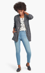 Load image into Gallery viewer, Front, full body view of a woman wearing the Nic + Zoe Ponte Ikat Jacket over a white printed top and with fitted jeans. The jacket is indigo with a white speck print all over it. It has a flat, notched lapel, and a front, off-center zipper.
