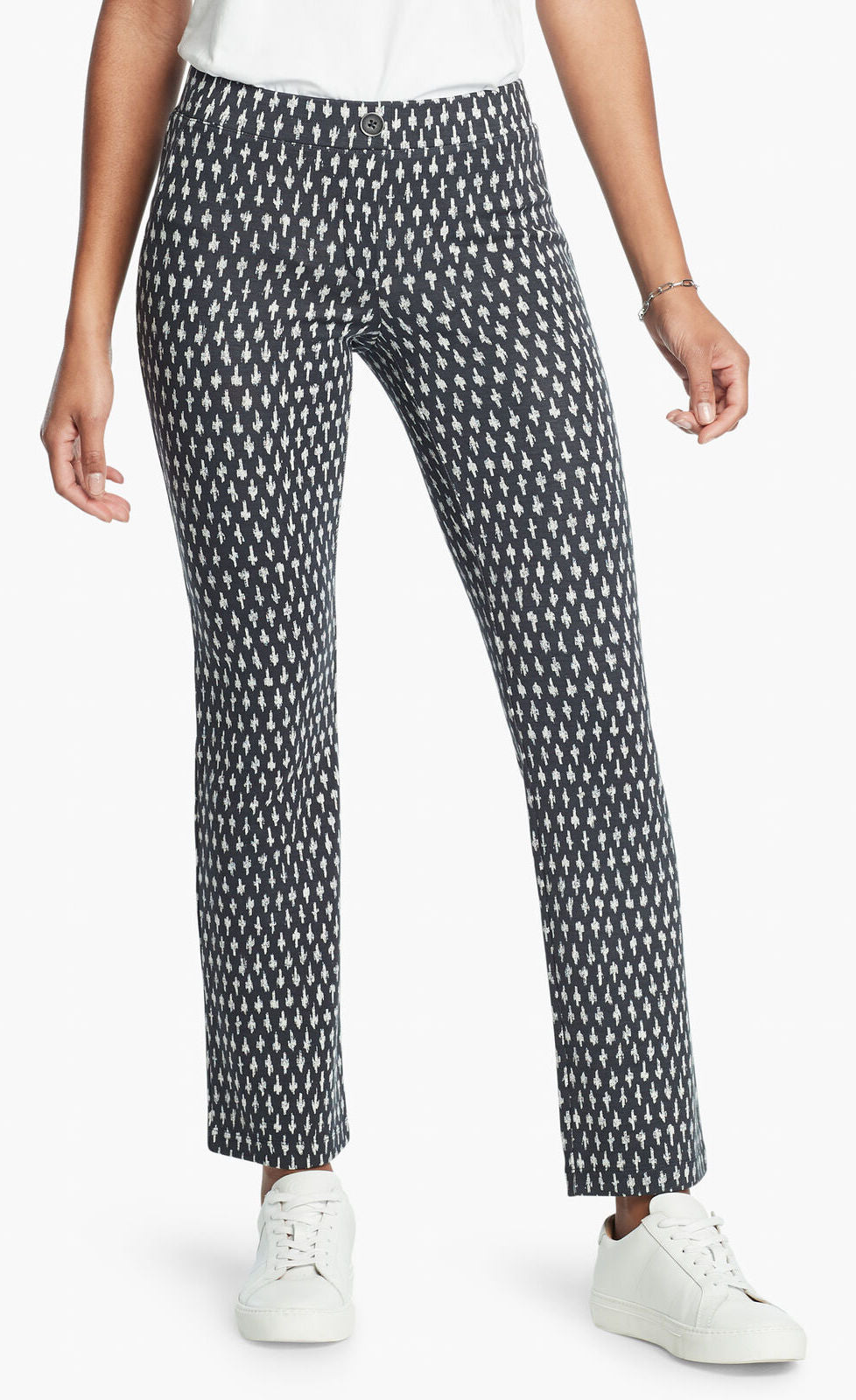 Front, bottom half view of a woman wearing the Nic + Zoe Ponte Ikat Pant. These pants are indigo with white speckled print. They have a straight leg and sit above the ankles.