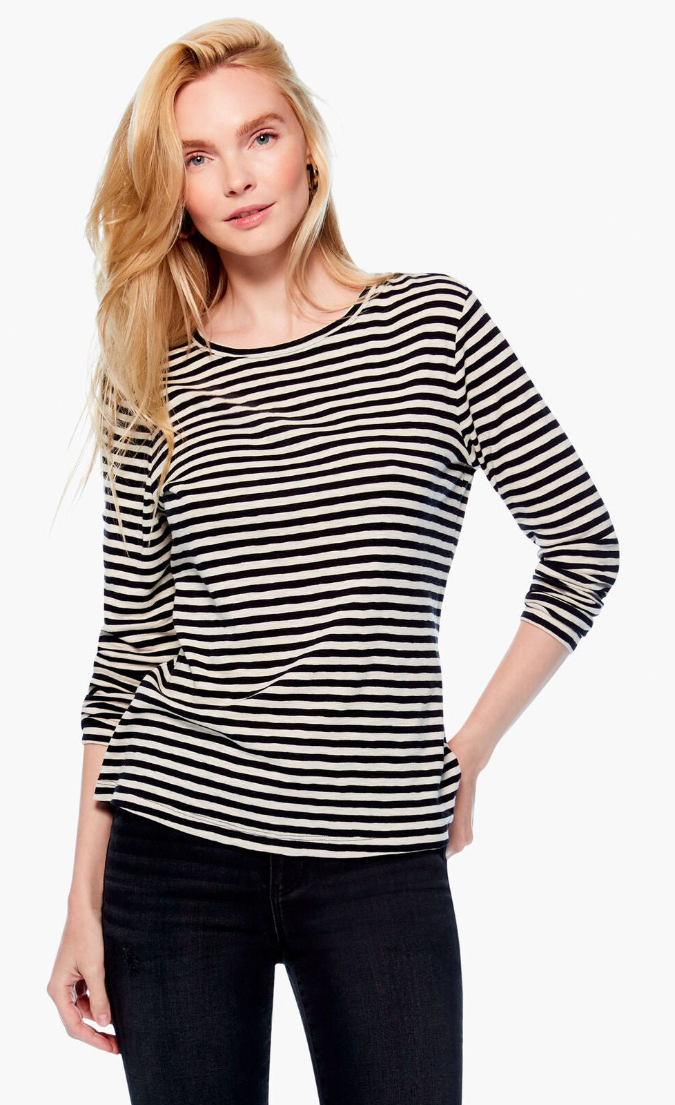 Front top half view of a woman wearing black pants and the nic + zoe saturday stripe top. This top is black and white striped. It has long sleeves and a round neck.