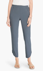 Load image into Gallery viewer, Front bottom half view of a woman wearing the Shirt Tail Tech Stretch Pant in slate grey. This pant has a straight leg, a cropped length, and an asymmetrical hem.
