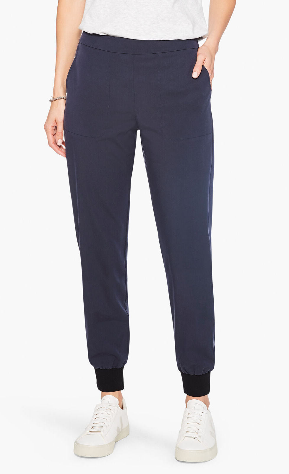 Front bottom half view of a woman wearing the nic and zoe stretch tencel jogger. These joggers are dark indigo with a tapered fit and side pockets.