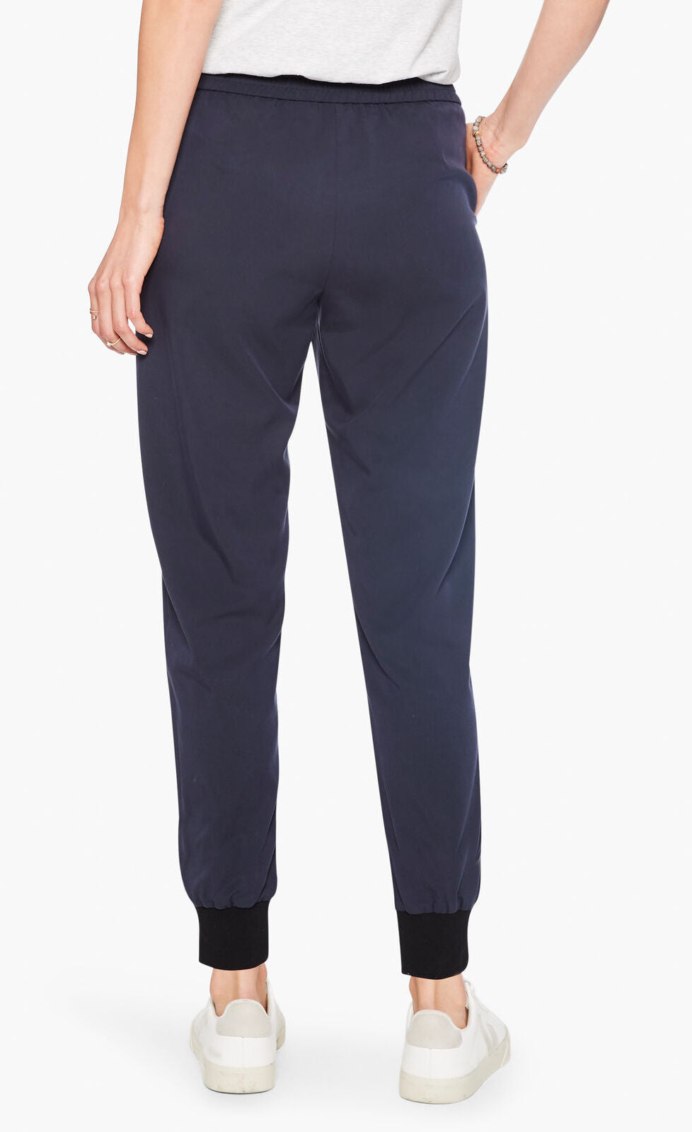 Back bottom half view of a woman wearing the nic and zoe stretch tencel jogger. These joggers are dark indigo with a tapered fit and side pockets.