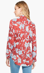 Load image into Gallery viewer, Back top half view of a woman wearing the terracotta blooms shirt from nic and zoe. This shirt has a relaxed fit with long sleeves. The shirt is red with a light blue floral print.
