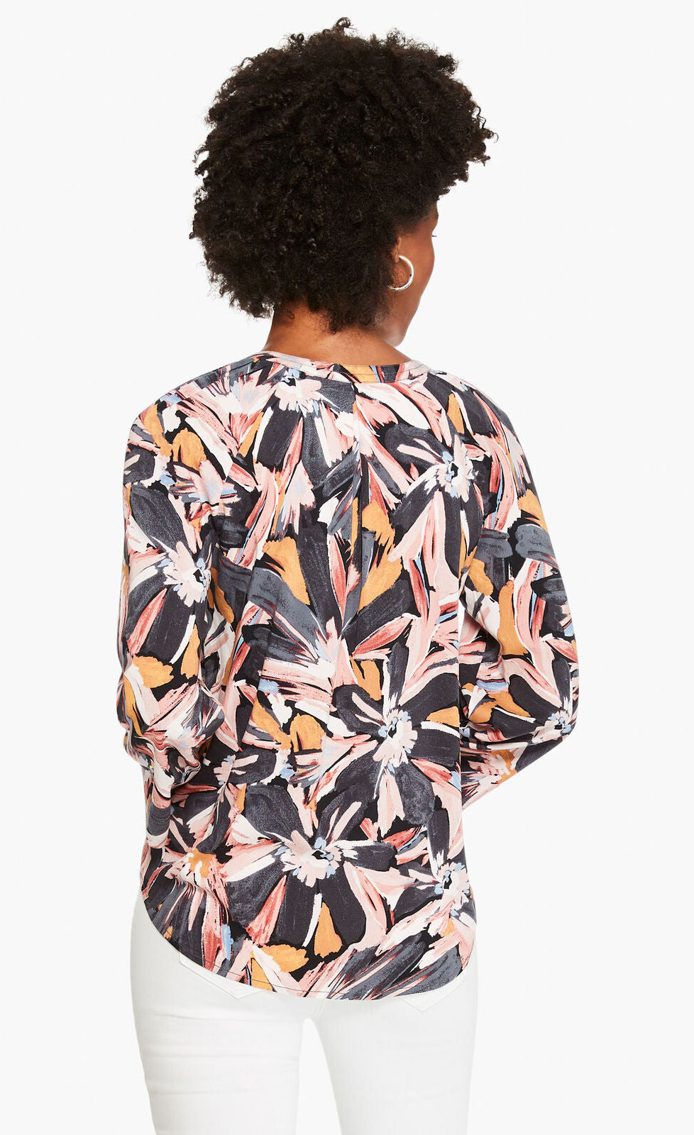 Back top half view of a woman wearing the nic and zoe zenergized live in top. This top has a large grey, pink, and mustard floral print. The top also has long sleeves and a v-neck.