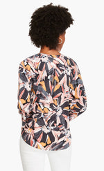 Load image into Gallery viewer, Back top half view of a woman wearing the nic and zoe zenergized live in top. This top has a large grey, pink, and mustard floral print. The top also has long sleeves and a v-neck.
