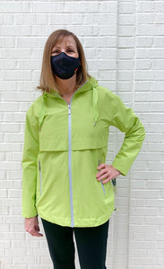 Front top half view of woman wearing the nikki jones magic print lime rain jacket. This jacket has a zipper front with two front zipper pockets, front venting over the chest and an adjustable hood and hem.