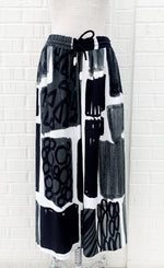 Load image into Gallery viewer, Front view of the crea concept black and white print pant. This pant has an abstract print on it, a wide leg, and an elastic waistband with a drawstring.
