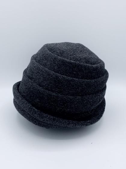 Left side view of the lillie & cohoe beatrice hat. This hat is grey with a tiered/folded crown and a rounded brim.