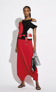 Front full body view of a woman wearing the Oblique Creation black red and white Cold Shoulder top with the Oblique Creations Red Knit Pant/Skirt. These bottoms have a very low drop crotch that make them look like a skirt.
