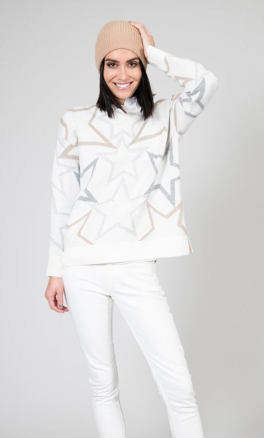 Front full body view of a woman wearing the ost baby you're a star sweater. This sweater is ivory colored with grey, white, and gold stars all over it. The sweater has a boxy silhouette and long sleeves.
