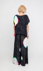 Load image into Gallery viewer, Back full body view of a woman wearing the ozai n ku orbits top in black multi. 
