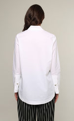 Load image into Gallery viewer, Back top half view of a woman wearing the Ozai N Ku White Shirt. This shirt is a classic white shirt cuffed long sleeves.
