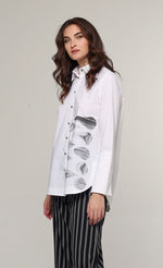 Load image into Gallery viewer, Front top half view of a woman wearing the Ozai N Ku White Shirt. This shirt is a classic white shirt with a grey marble abstract print on the front left side of the shirt. The shirt has a button down front and long sleeves.
