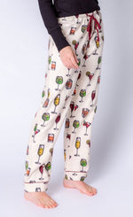 Load image into Gallery viewer, Front Bottom half view of a woman wearing the pj salvage call me old fashioned flannel pj set. The model has on an ivory colored long pant with cocktail glasses all over it and a wine colored drawstring waistband.
