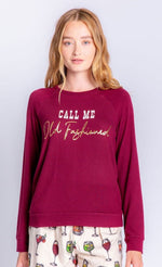 Load image into Gallery viewer, Front top half view of a woman wearing the pj salvage call me old fashioned flannel pj set. The model has on a wine colored long sleeves that says call me old fashioned. She is also wearing an ivory colored pant with cocktail glasses all over it.
